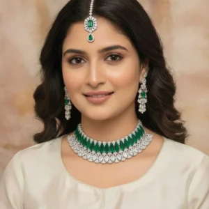 Premium Emerald Green American Diamond choker necklace set with matching long earrings and maang tikka featuring sparkling cubic zirconia and emerald green stones for bridal and wedding wear.