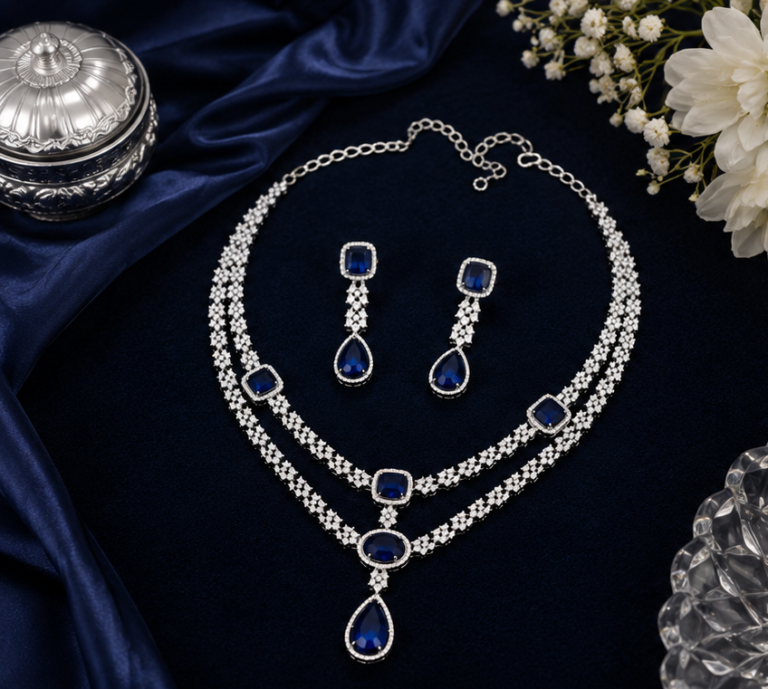 Premium silver finish layered American Diamond necklace set with royal sapphire blue stones and matching drop earrings, ideal for bridal, wedding, reception, and party wear.
